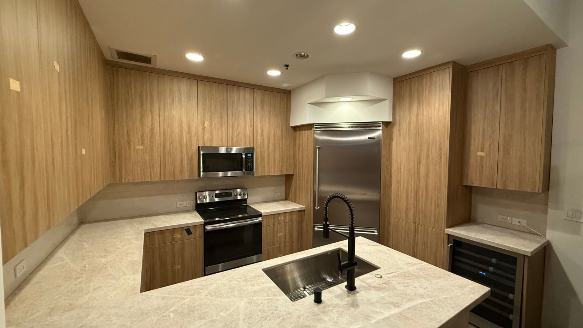 Real JMF Builders kitchen remodel with wood-grain cabinets and marble-look countertops